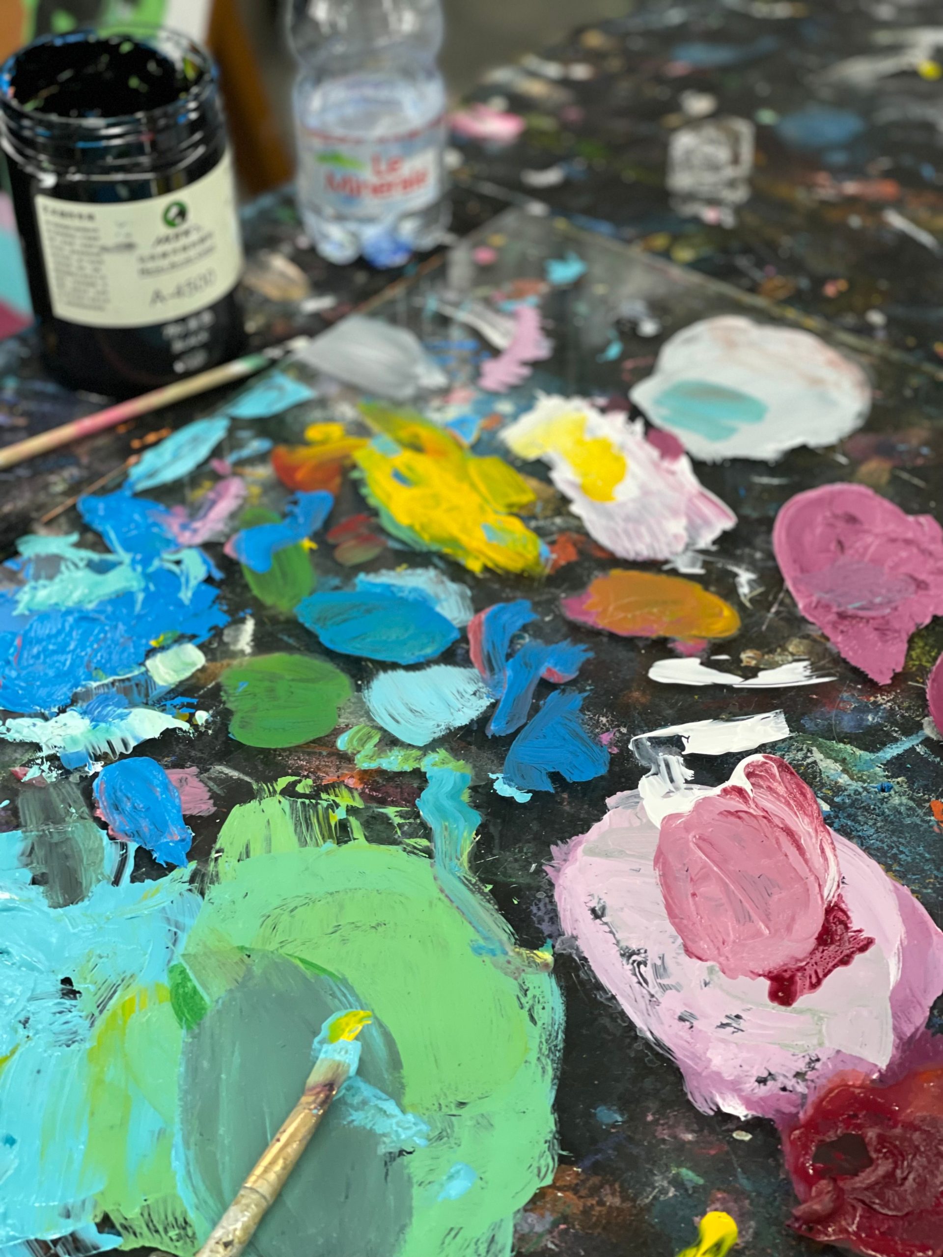 Vibrant acrylic paints on a messy artist's palette, showcasing creativity.