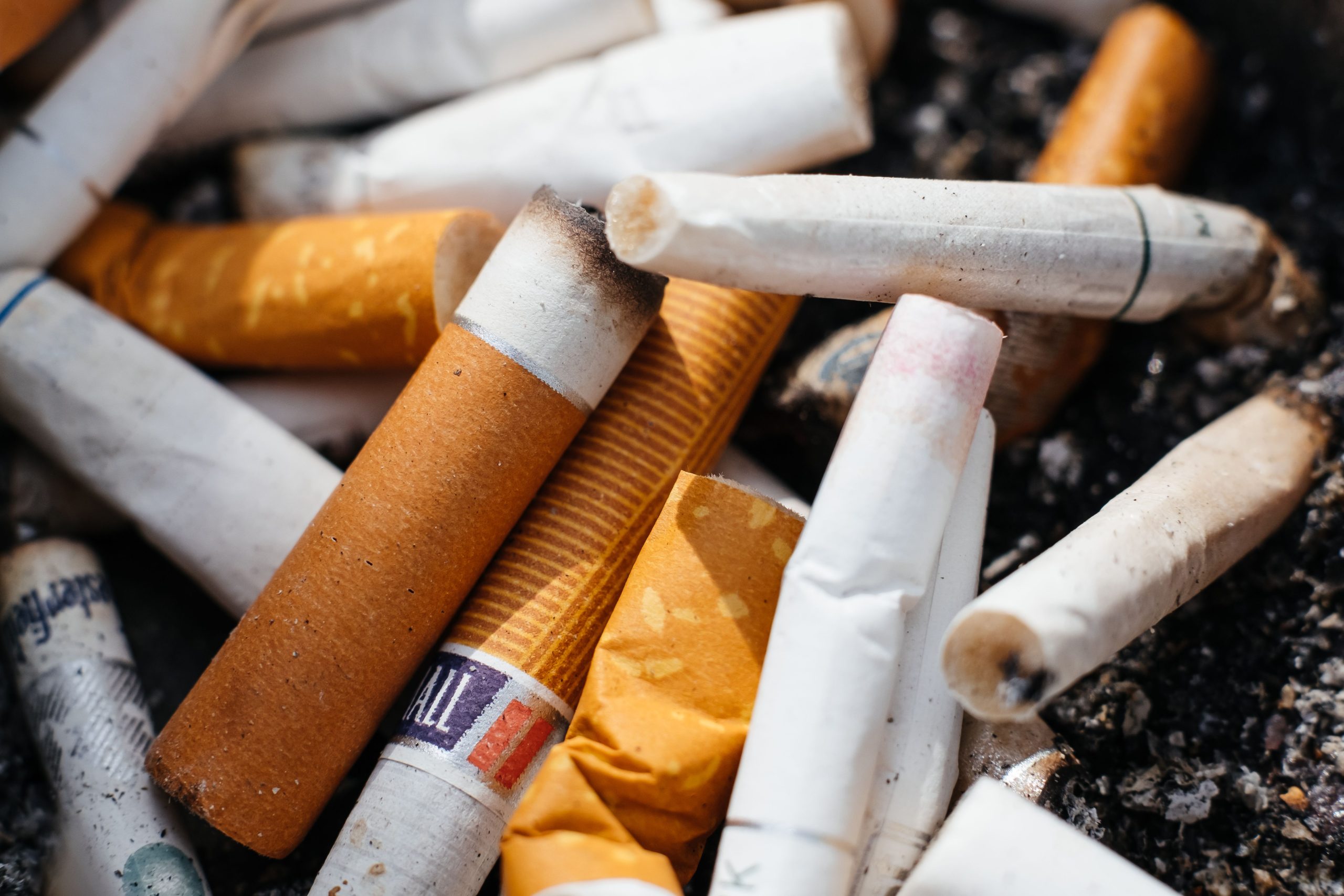Cigarette butts in an ashtray emphasize the environmental impact of smoking.